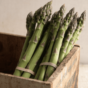 Fresh green asparagus bundled and placed in a rustic wooden crate.